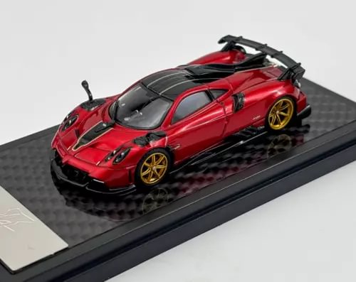 Red sports model diecast car with black rear wing, gold wheels, on display base
