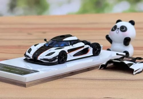 Alloy diecast sports car model with white body, black stripes, and panda figurine