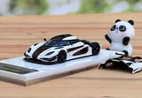 Alloy diecast sports car model with white body, black stripes, and panda figurine