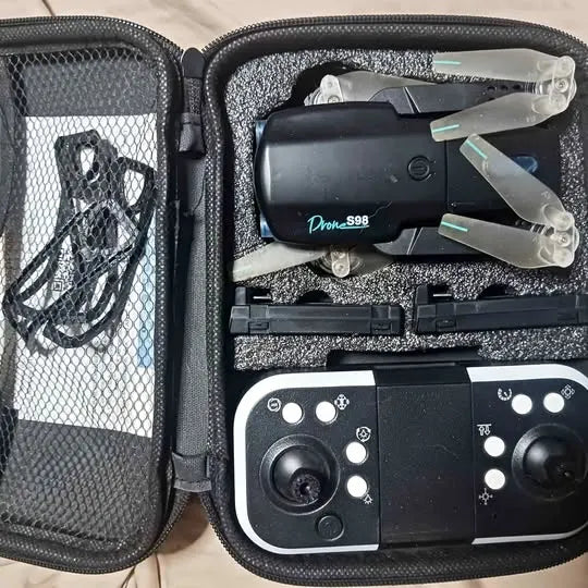 Black drone with propellers and controller in open hard-shell case