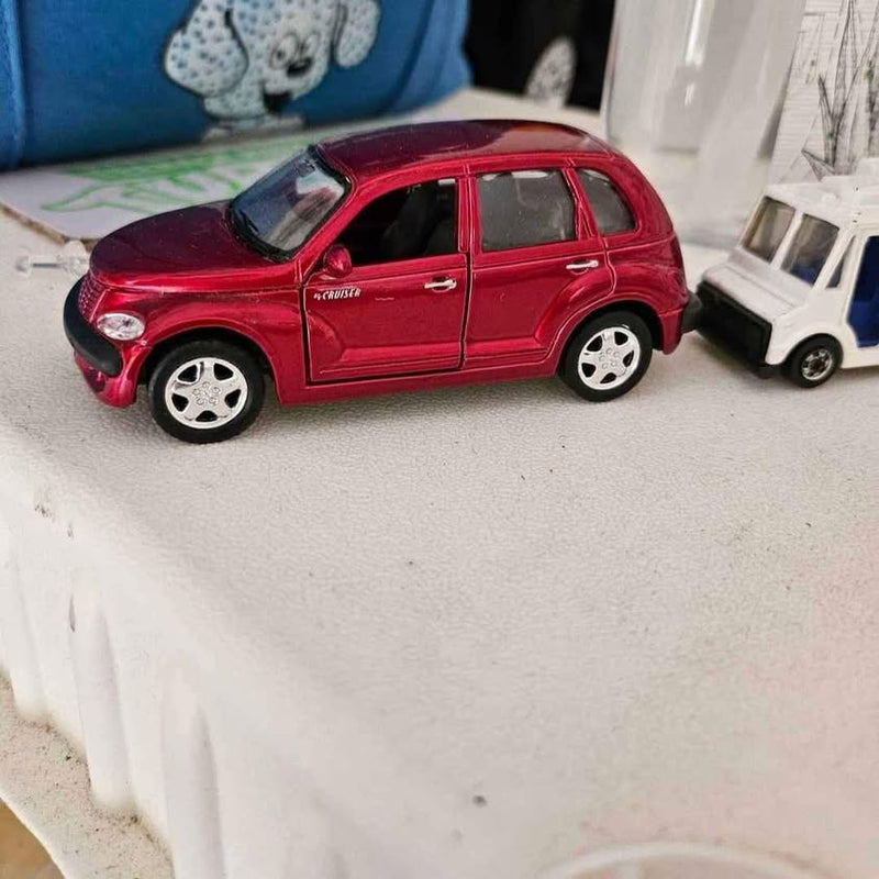 Red diecast PT Cruiser model car with black roof, side view