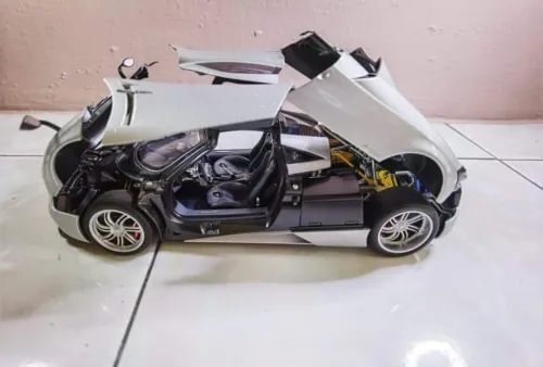 Silver 1:18 diecast model car with open hood, showing engine and front details