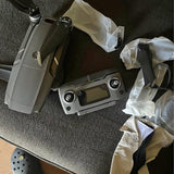 Folded drone with camera and propeller guards, gray body and black accents