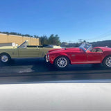 Red and cream diecast classic cars, front three-quarter view with chrome wheels