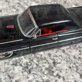 Diecast 1963 Cadillac model car, dark exterior with chrome trim and red interior detail