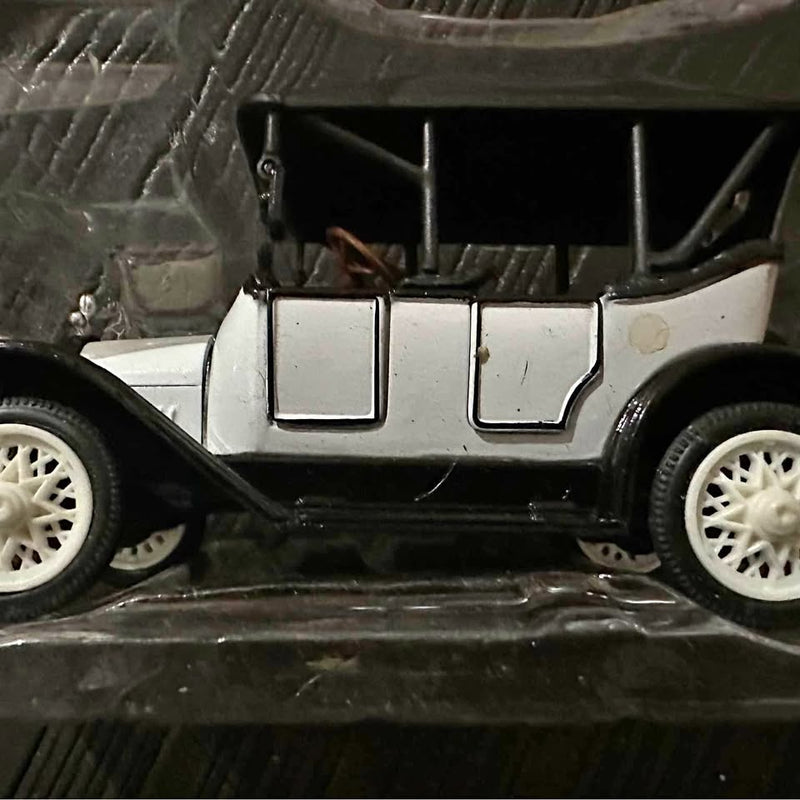 Vintage diecast metal car model with white body, grille, and front wheels