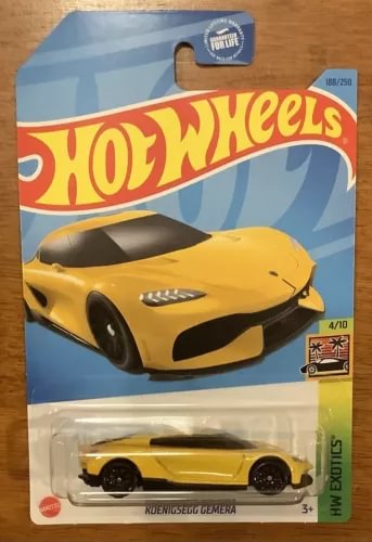 Hot Wheels diecast toy car, yellow with black accents, in blister packaging
