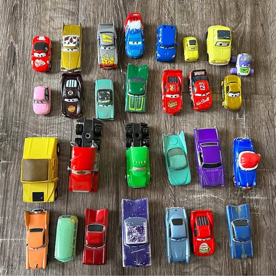 Assorted small diecast toy cars, various colors, top view layout