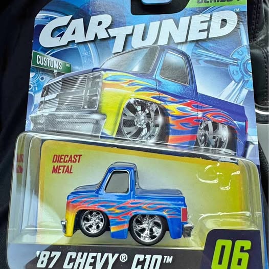 Diecast 1987 Chevy C10 pickup truck in blue with flame graphics, in retail box