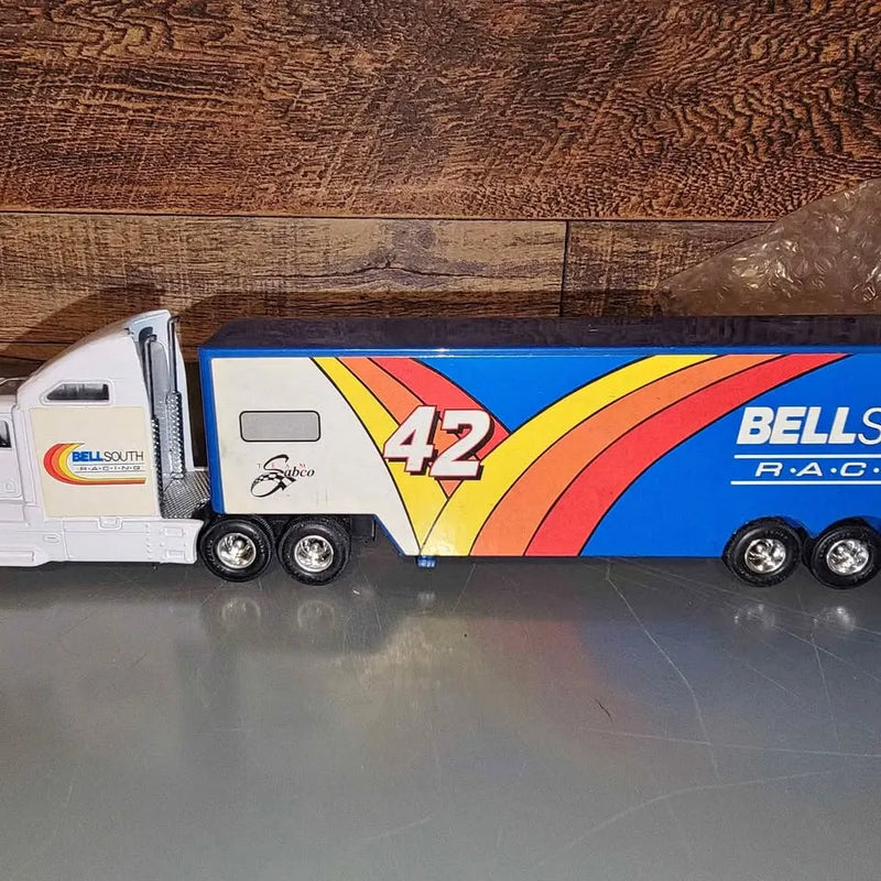 Diecast tractor-trailer model with white cab and blue cargo trailer with colorful racing stripes