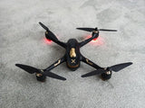 Black quadcopter drone with four propellers and front camera housing
