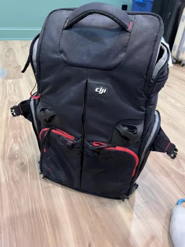 DJI drone backpack, dark gray with front pockets, zipper compartments, red trim