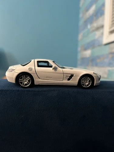 White diecast model toy car, side view with detailed wheels and grille