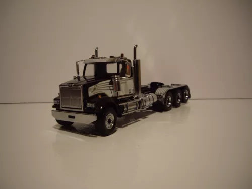 Black and white tri-axle diecast semi truck model with chrome grille and cab details