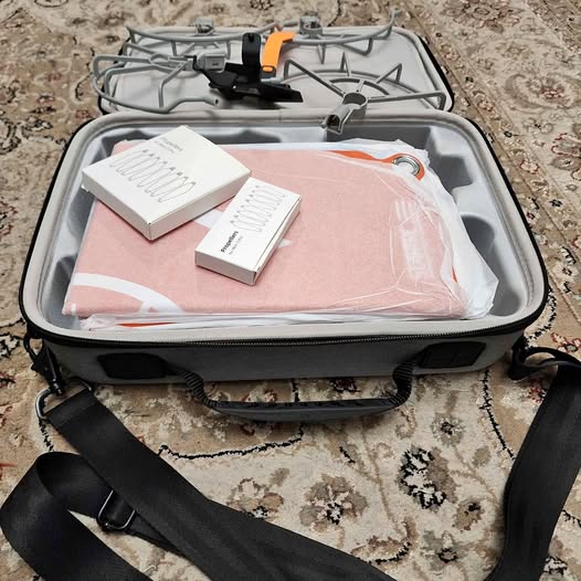 Hard travel carrying case, open with foam-lined compartments and black carry straps