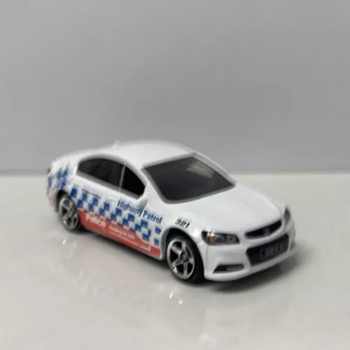White 1/64 scale diecast car model with blue checker and red side stripes
