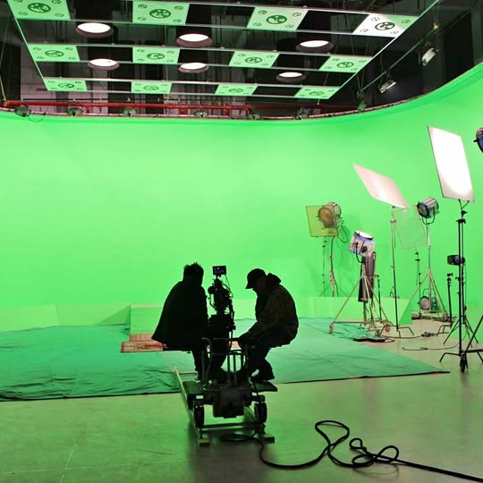 Studio drone on floor with cables, in front of green screen