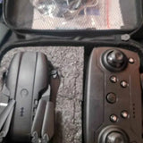 Brown handheld remote controller with black thumb dials and multiple buttons