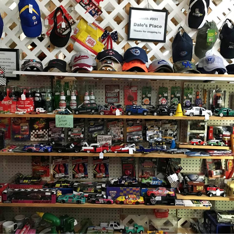 Diecast toy car assortment on pegboard shelves, assorted colors and racing designs.