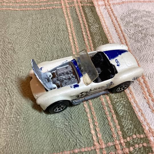 1/64 scale white diecast race car with blue accents and detailed engine bay
