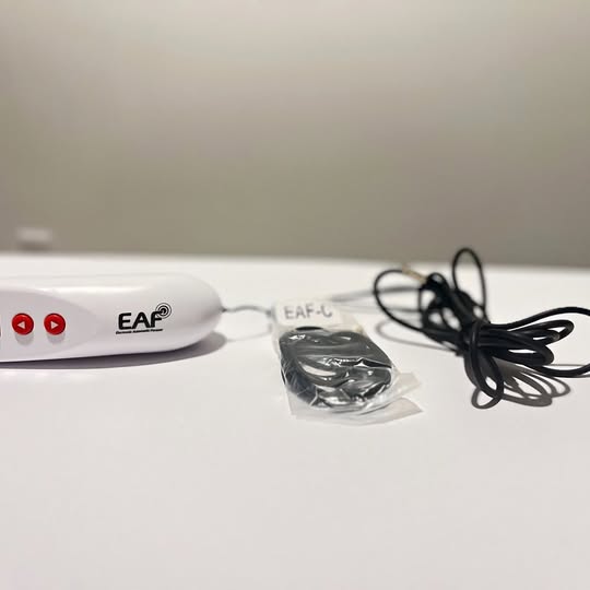 White EAF hand controller with buttons, cable, and wrapped connector