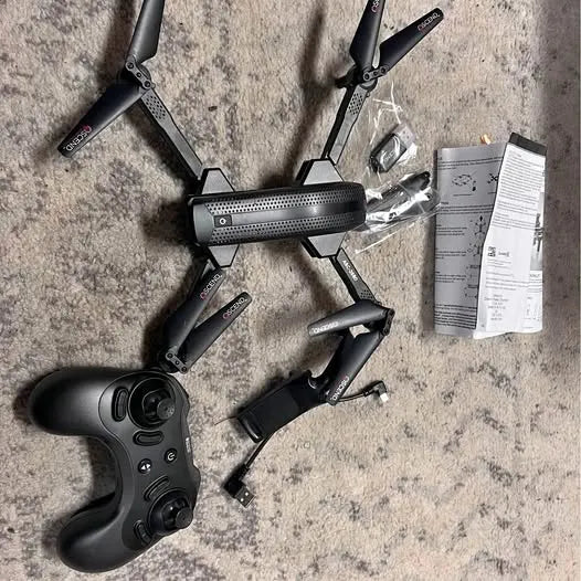 Black foldable quadcopter drone with controller and spare propeller package