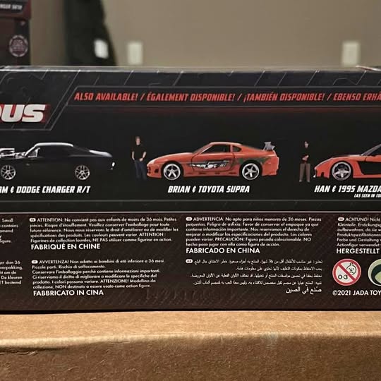Diecast toy car blister pack with orange sports car illustration and rear text