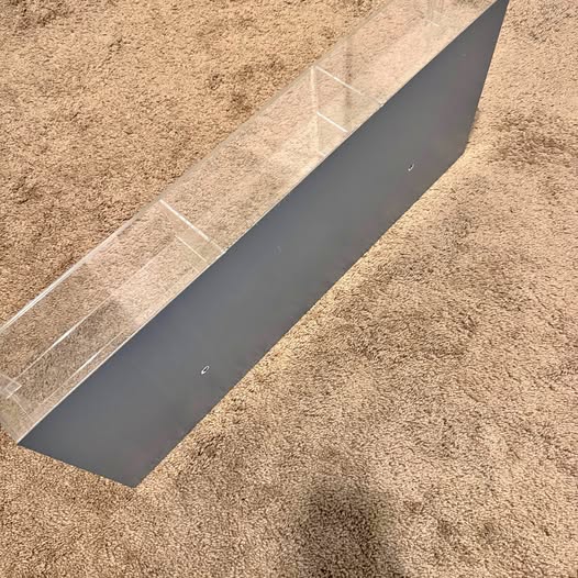 Wall-mounted die-cast car display case with clear glass front and dark backing