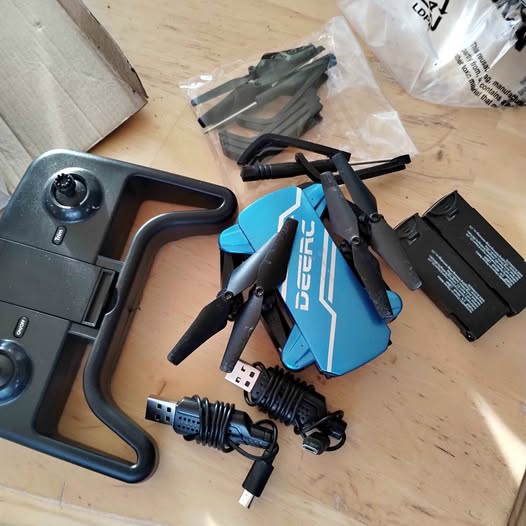 DEErC drone kit: blue quadcopter with controller grip, cables, and spare batteries
