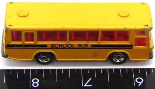 Yellow school bus diecast toy, side windows, SCHOOL BUS lettering.