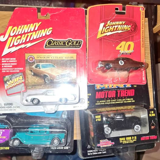 Diecast model car blister packs with red and teal cars, Johnny Lightning branding