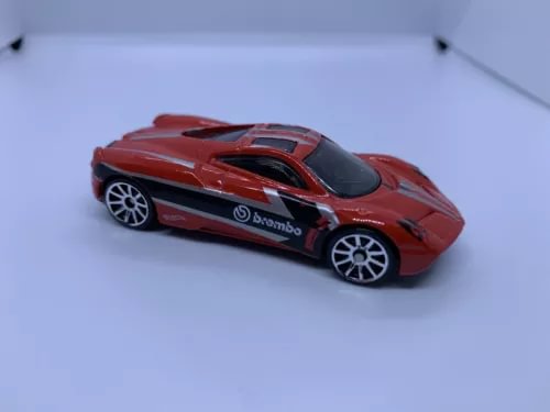 Red diecast sports car model with black hood stripe and Brembo-style logo