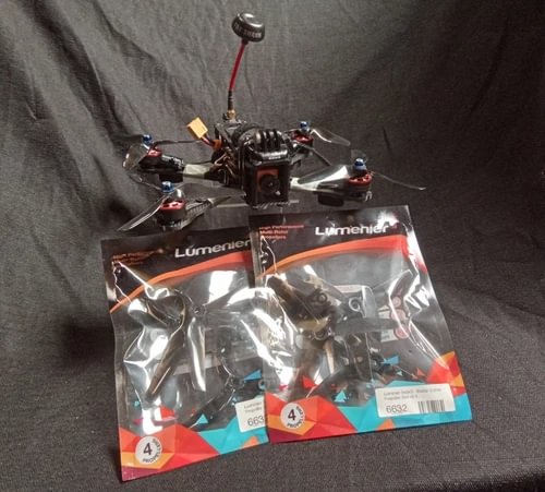FPV racing drone with propellers and Lumenier kit packaging