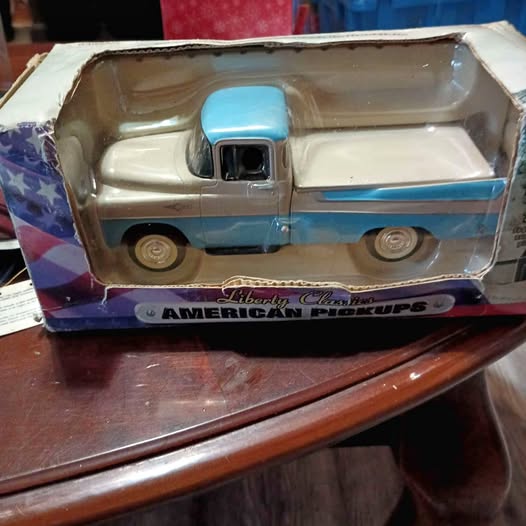 Diecast pickup truck with blue cab and light beige body, in display box.