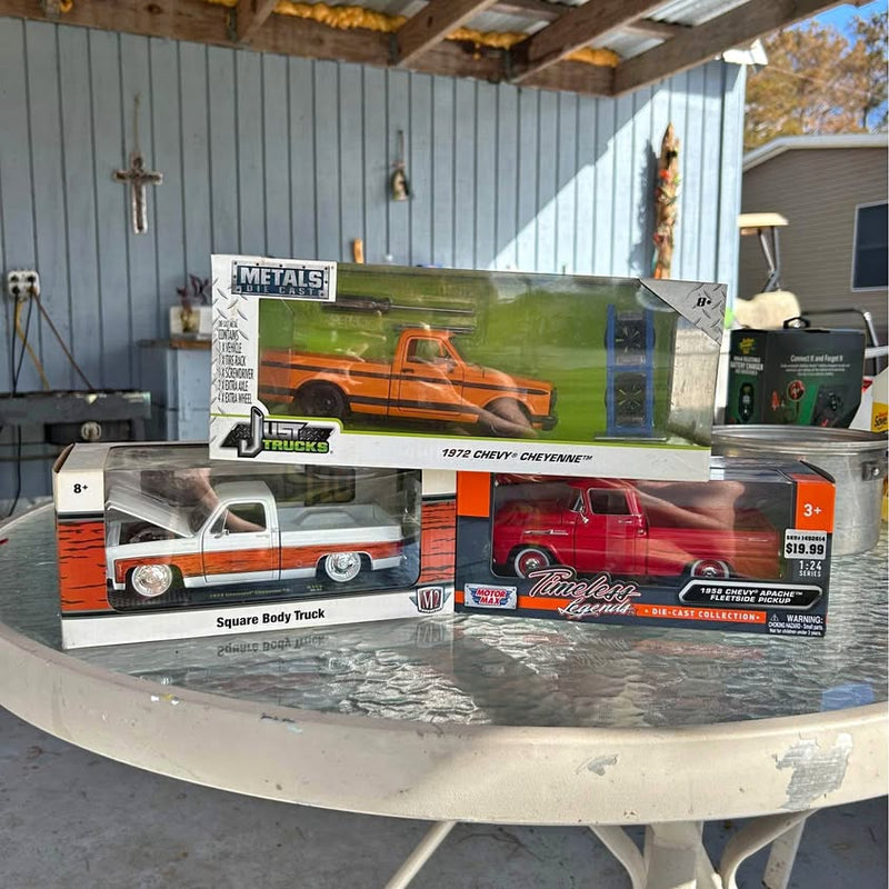 Diecast truck in box with orange and silver pickup graphics