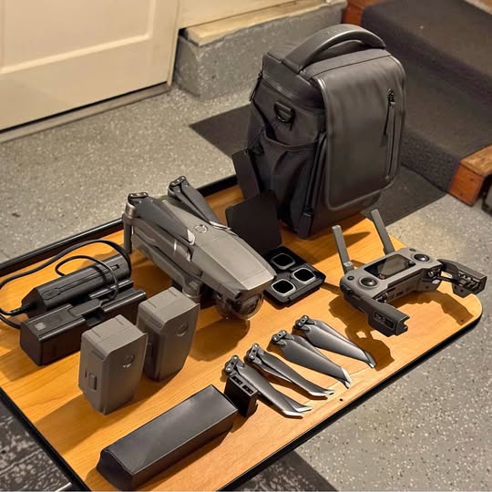Drone and accessories set with carrying bag, including controller and batteries.