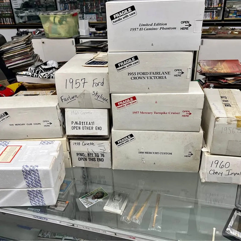 Diecast car model boxes stack with labeled 1957 Ford and Mercury models.