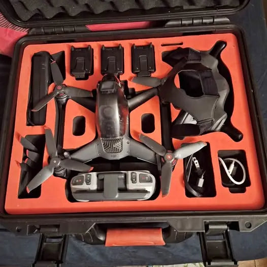 DJI FPV drone with controller, props, and parts in orange foam case