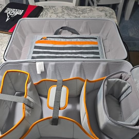 Drone guard case interior with gray padding, orange straps, and mesh pocket.