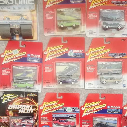 Assorted Johnny Lightning diecast cars in blister packs, various vehicle colors