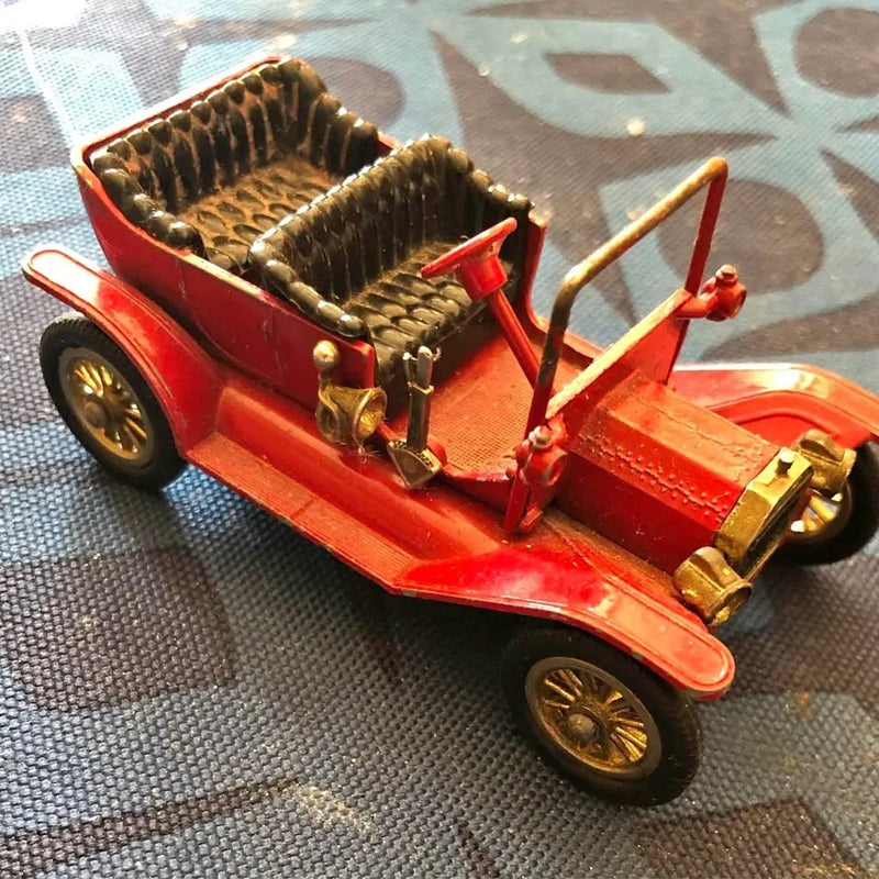 Red diecast open-top Model T car with front grille and visible leather-style seats