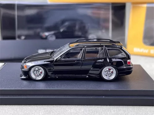 Black BMW M3 E36 Touring diecast model car, 1/64 scale, front 3/4 view with silver wheels