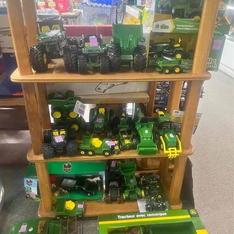 Green diecast tractor assortment on wooden display shelf