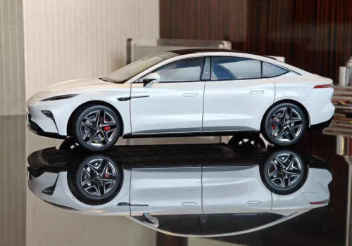 White 1:16 scale diecast model car, side view with detailed wheels and headlights