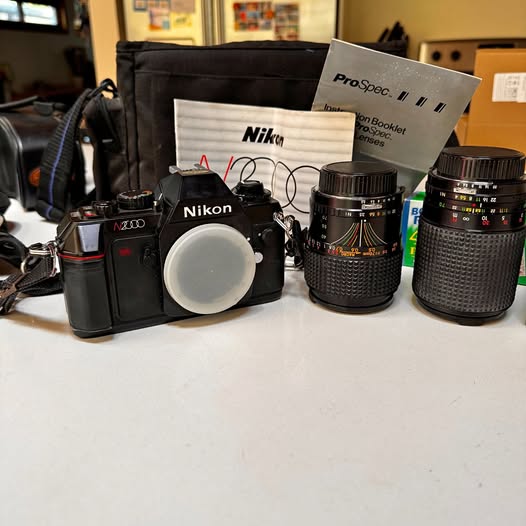 Nikon film camera kit with lenses and carrying bag