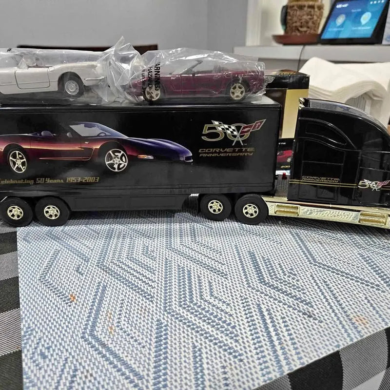 Diecast truck in display box, black with gold trim and car graphics on front