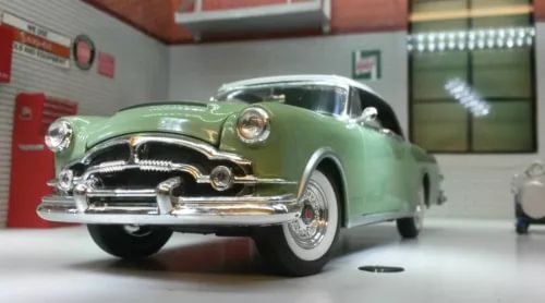 Green vintage diecast model car with chrome front bumper and grille