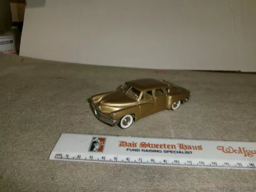 Gold diecast model car, front three-quarter view