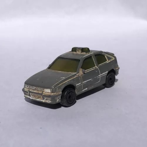 Vintage diecast car model, dark gray sedan with side stripes and black wheels.