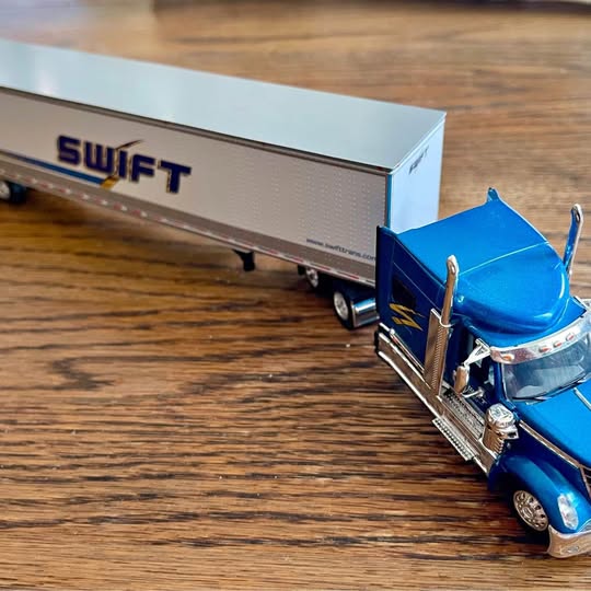 Diecast Swift tractor trailer replica with blue cab and silver trailer, front 3/4 view